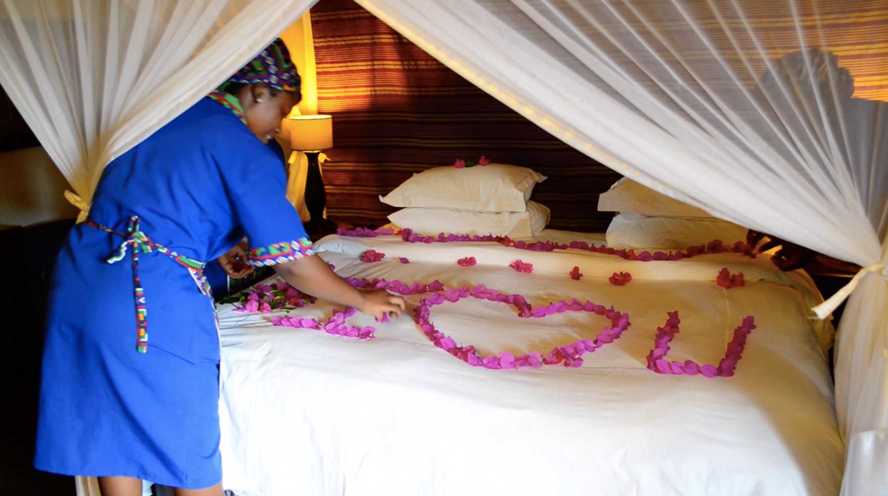 Linki and her team of housekeeping staff at Umkumbe dressing a bed for a honeymoon couple
